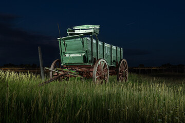 An old carriage  sits in a field in rural South Dakota.