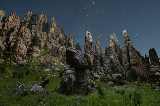 Massive spires of the Black Hills illuminated at night by a dron