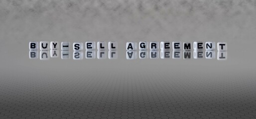 buy sell agreement word or concept represented by black and white letter cubes on a grey horizon...