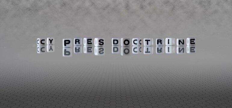 cy pres doctrine word or concept represented by black and white letter cubes on a grey horizon background stretching to infinity
