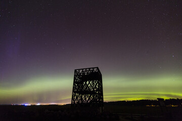 Shot of wooden watchtower outdoor with aurora in Estonia