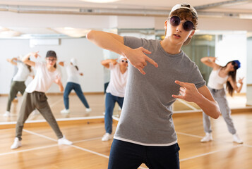 Fototapeta na wymiar Portrait of teenager boy performing hip hop at group dance class