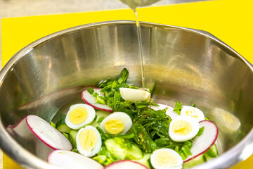 Kale, avocado, radish, cucumbers, olive oil salad and soft boiled egg - delicious healthy breakfast, snack on a light background