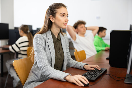 Focused Young Woman Sitting At Table In Computer Room In Public Library. Self-study Concept..