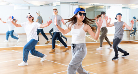 Teenagers boy and girls performing hip hop at group dance class
