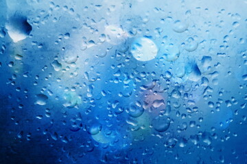  rain drops on window glass  in night  town  rainy weather background blurred city light defocus
