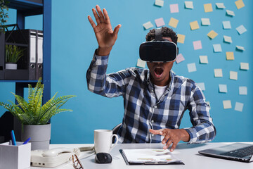 Astonished scared office worker wearing virtual reality headset while enjoying simulation game....
