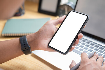 Close up view of man holding mock up smart phone with blank screen.
