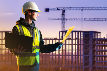 A civil engineer on the background of a building frame and cranes. A man looks at construction...