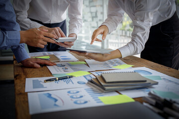 Financial analyst analysis business financial report on a digital tablet during a discussion a meeting of corporate showing the results of successful  Marketing teamwork and business meeting concept.