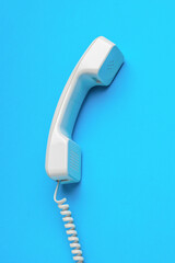 Classic handset with a wire on a blue background.