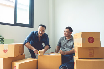 LGBTQ couples are packing boxes to move house. They lived happily ever after, covering the boxes with tape to prepare them for transport.