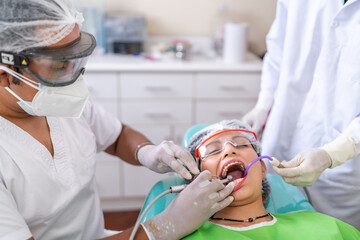 Dentist cleaning the mouth of a patient using modern equipment