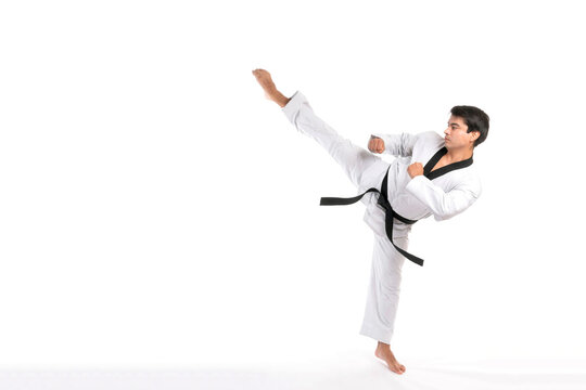 Taekwondo High Kick - Black Belt  Taekwondo Athlete Martial Arts Master , Handsome Man Show High Kick Pose During Fighter Training Isolated On White Background