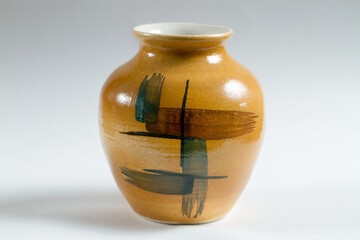 A small clay jug on a gray background.