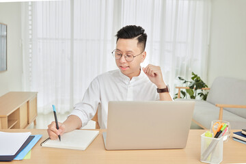 A moment of young working with laptop at home in living room background 