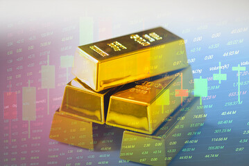 Gold trading, gold bars on fabric with stock graph chart stock market trade background, pile of...