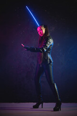 Concept of futuristic woman soldier with the katana sword in the neon lights.