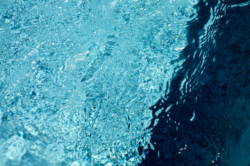 Ripples and light reflections on blue water surface