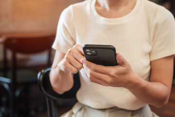 Casual Businesswoman holding and using smartphone for sms messages, young woman typing touchscreen mobile phone in cafe or modern office. lifestyle, technology, Social media and network concept