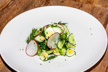 Kale, avocado, radish, cucumbers, olive oil salad and soft boiled egg - delicious healthy breakfast, snack on a light background