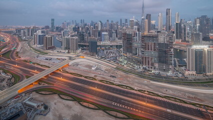 Panoramic skyline of Dubai with business bay and downtown district night to day timelapse.