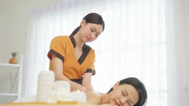 Asian young woman feeling happy and relax during back massage with oil.	
