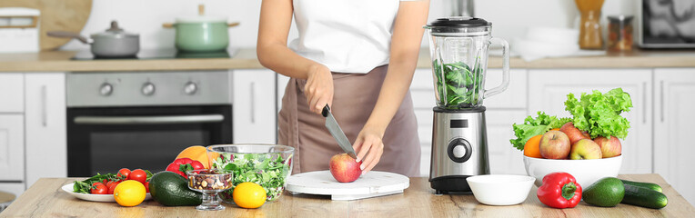 Young woman cutting products for smoothie in kitchen