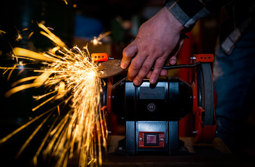 The process of sharpening scissors on metal with the release of a large number of bright sparks