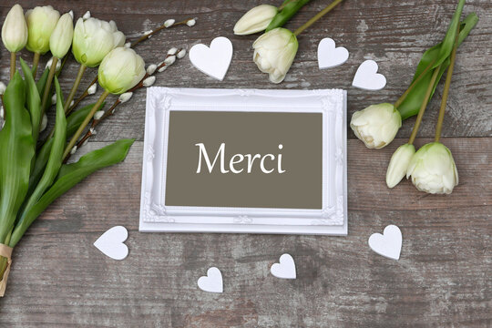 Cadre avec le mot Merci avec des tulipes et des coeurs.