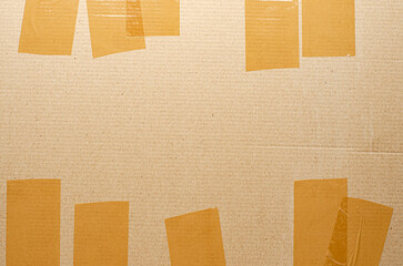Brown tape on cardboard. The concept of transporting things, sending a donation or packing parcels....
