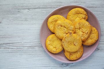 Homemade Lemon and White Chocolate Cookies on a Plate on a white wooden surface, top view. Flat lay, overhead, from above. Copy space.