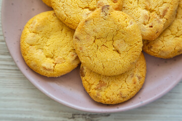 Homemade Lemon and White Chocolate Cookies on a Plate on a white wooden background, top view. Flat lay, overhead, from above. Close-up