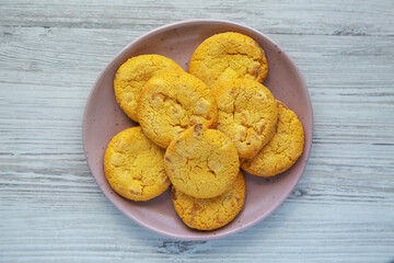 Homemade Lemon and White Chocolate Cookies on a Plate on a white wooden background, top view. Flat lay, overhead, from above.