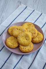 Homemade Lemon and White Chocolate Cookies on a Plate on a white wooden background, side view.