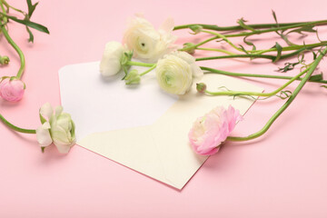 Empty envelope and beautiful ranunculus flowers on pink background, closeup