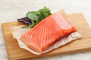 Raw salmon fillet over board