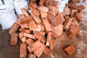 Building red ceramic bricks thrown into the garbage. Construction garbage