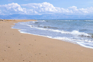 Sandy beach with sea waves at resort on sunny day