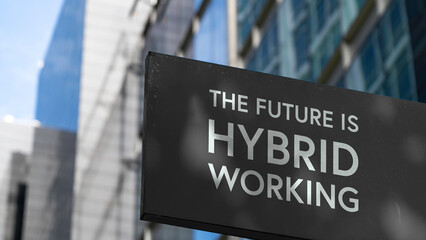 The Future is Hybrid Working on a black city-center sign in front of a modern office building	
