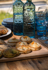 Argentinian stuffed pastries on table with glass bottles and cups