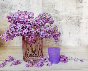 Purple candle and lilac flowers bouquet 
