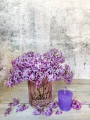 Purple candle and lilac flowers bouquet 
