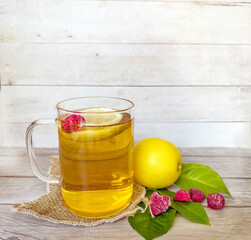 Kombucha tea with lemon and raspberry in glass cup 