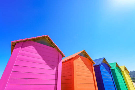 Vibrant colourful wooden huts against clear blue sky with copy space