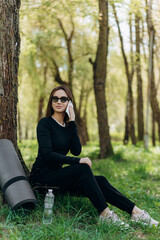 Young woman doing sports and listening to music in the park