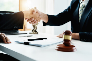 Law, consultation, agreement, contract, lawyer or attorney shakes hands to agree on the client's offer to be hired to fight the parties in court.