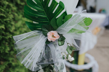 Wedding floral decoration with a small flower and green ferns on a white tulle