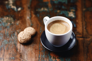 Cup of coffee with Amaretti (Italian biscuits) on rustic wooden background. Copy space.                                                                                                                 