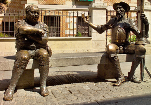 Statue of Don Quixote and Sancho Panza on a street bench in the Cervantes Museum House in Alcal&aacute; de Henares, Madrid - Spain